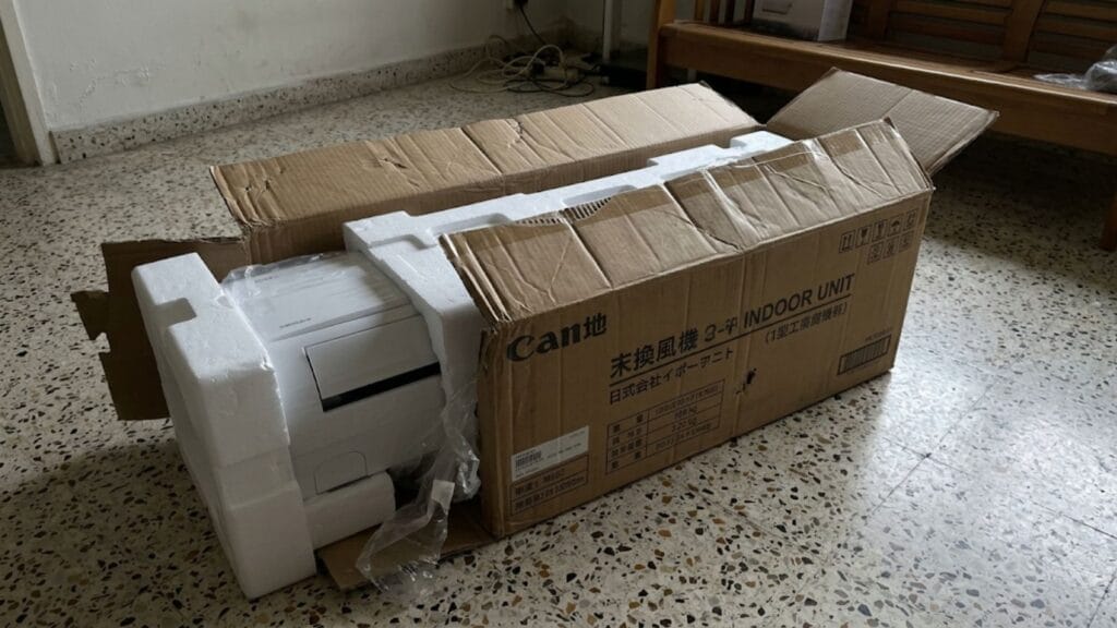 Imported air conditioner unit being unboxed in a Singapore HDB flat