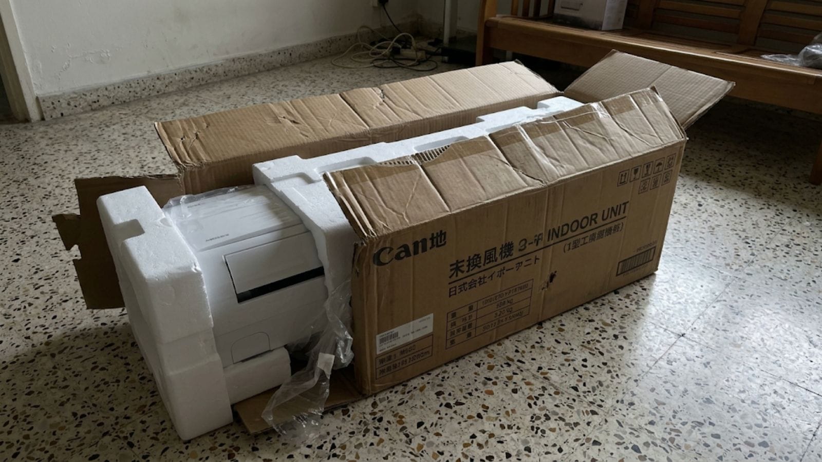 Imported air conditioner unit being unboxed in a Singapore HDB flat
